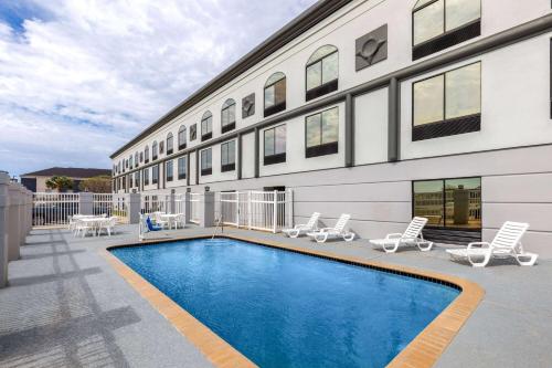 a swimming pool in front of a building at Wingate by Wyndham Sulphur Near Lake Charles in Sulphur