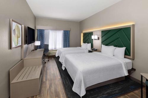 a hotel room with two beds and a television at Wingate by Wyndham Sulphur Near Lake Charles in Sulphur