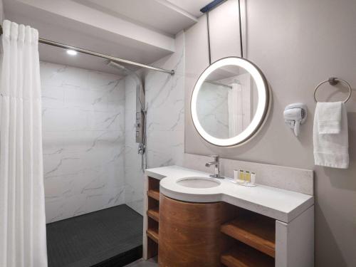 La salle de bains est pourvue d'un lavabo et d'un miroir. dans l'établissement Days Inn by Wyndham Las Vegas Airport Near the Strip, à Las Vegas