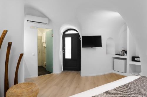 a bedroom with white walls and a black door at Mill Houses New Elegant Suites in Firostefani