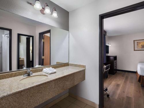 a bathroom with a sink and a large mirror at Travelodge by Wyndham Tucson AZ in Tucson