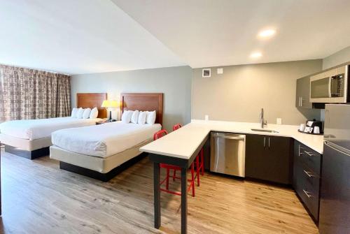 a hotel room with two beds and a kitchen at Hawthorn Extended Stay by Wyndham Ellsworth Bar Harbor in Ellsworth