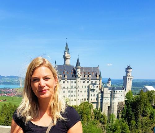 a woman standing in front of a castle at Ferienwohnung-Allgaeu-Pfronten -Inkl KönigsCard Fewo FALKENSTEIN in Pfronten