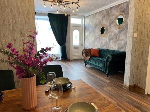 sala de estar con mesa y sofá verde en Charming, spacious and cosy home in HULL en Hull