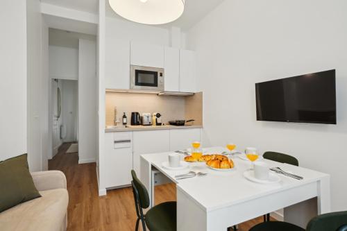 - une cuisine blanche avec une table et une assiette de nourriture dans l'établissement Appartement cosy à Saint-Ouen, à Saint-Ouen