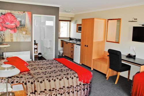 a hotel room with a bed and a desk at Beachcomber Inn Picton in Picton