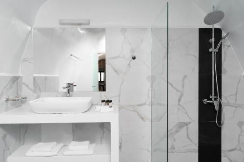 a white bathroom with a sink and a shower at Mill Houses New Elegant Suites in Firostefani