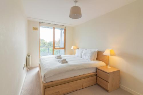 a white bedroom with a bed with a window at GuestReady - Luminous Elegance in Barrow Street in Dublin