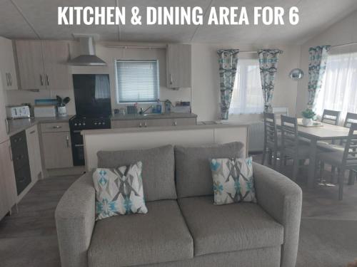 a living room with a couch and a kitchen and dining area at Greenshaw - extremely spacious in Rye Harbour