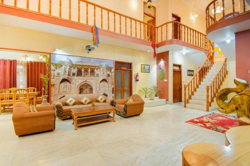 a large living room with couches and a staircase at OYO The Nandini's Guest House in Jaipur