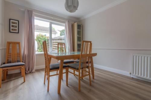 a dining room with a table and chairs and a window at GuestReady - A charming place near Golf Centre in Dublin