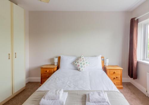 a bedroom with a bed with white sheets and a window at GuestReady - A charming place near Golf Centre in Dublin