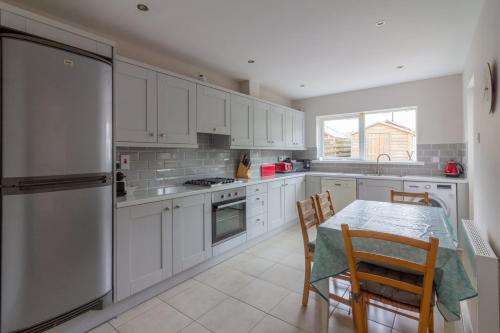a kitchen with white cabinets and a table with chairs at GuestReady - A charming place near Golf Centre in Dublin