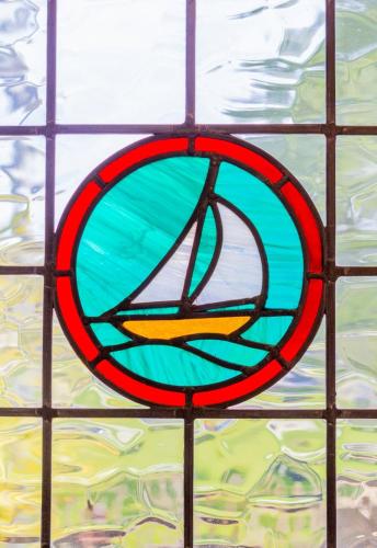 a stained glass window with a picture of a ship at GuestReady - Impressionante Flat com Vista Terraço in Malahide