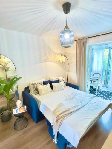 une chambre avec un lit bleu et une plante en pot dans l'établissement Studio à Portissol avec parking, à Sanary-sur-Mer
