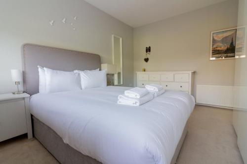 a white bed with two towels on top of it at GuestReady - Tranquil Retreat in Kimmage in Crumlin