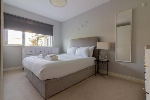 a bedroom with a large white bed with a window at GuestReady - Tranquil Retreat in Kimmage in Crumlin