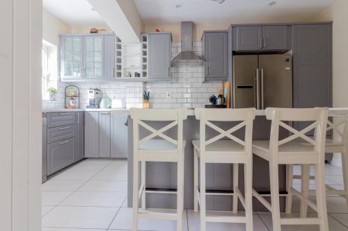 a kitchen with gray cabinets and white appliances at GuestReady - Tranquil Retreat in Kimmage in Crumlin