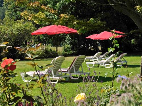 a group of lawn chairs and umbrellas in a yard at Hotel Royal St Georges Interlaken MGallery Collection in Interlaken