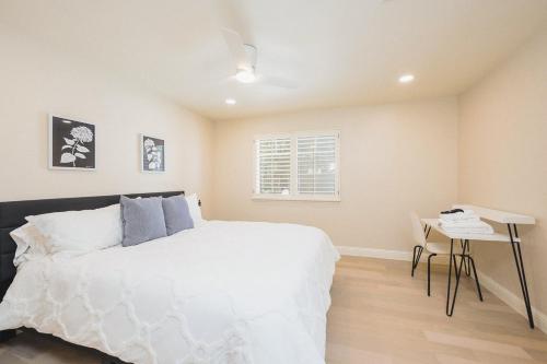 a white bedroom with a bed and a table at Casteel - 4,500 sq-ft retreat with a pool and hot tub in the middle of wine country! in Templeton