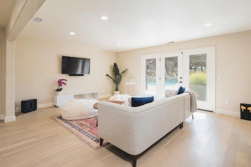 a living room with a couch and a tv at Casteel - 4,500 sq-ft retreat with a pool and hot tub in the middle of wine country! in Templeton