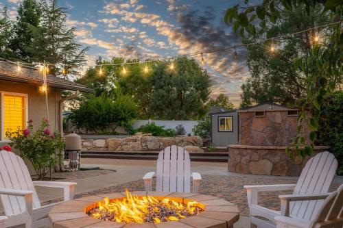 a backyard fire pit with two chairs and a table at Casteel - 4,500 sq-ft retreat with a pool and hot tub in the middle of wine country! in Templeton