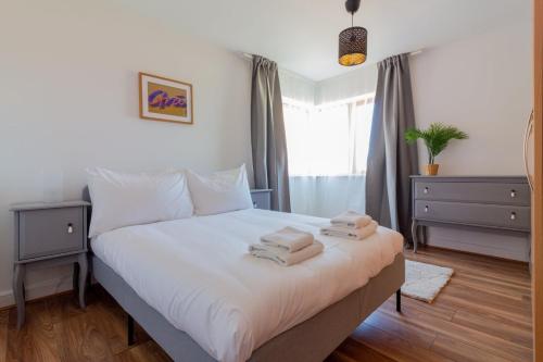 um quarto com uma cama com duas toalhas em GuestReady - Modern stay by Pheonix Park em Dublin