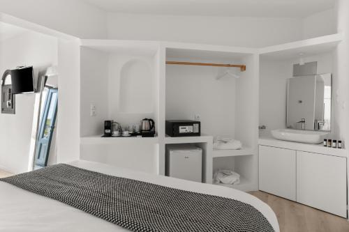 a white bedroom with a bed and a sink at Mill Houses New Elegant Suites in Firostefani