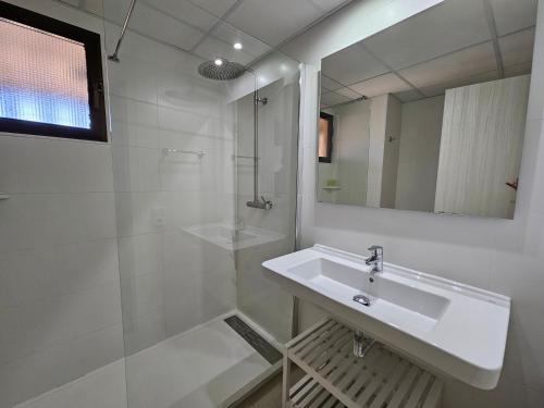 een witte badkamer met een wastafel en een douche bij Apartamentos Don Vicente in Benidorm