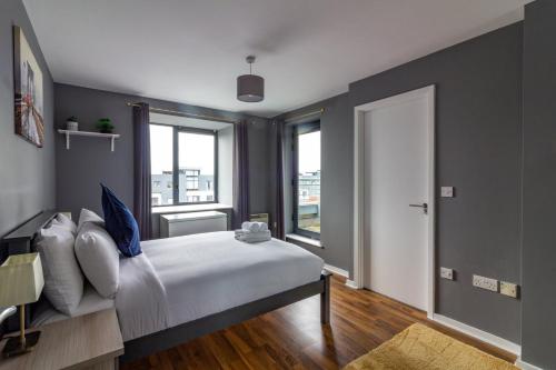 una camera da letto con un letto con pareti blu e una finestra di GuestReady - Royal Canal Park Chic Getaway a Dublino