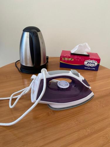 a tea kettle with a cord on a table at Madinat Happy Muscat House in Muscat