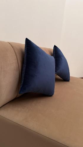 two blue pillows sitting on top of a couch at Madinat Happy Muscat House in Muscat