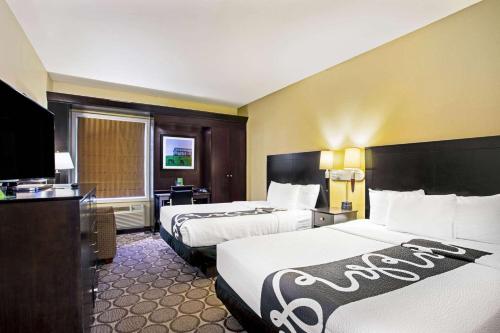 a hotel room with two beds and a television at La Quinta by Wyndham Lexington South / Hamburg in Lexington