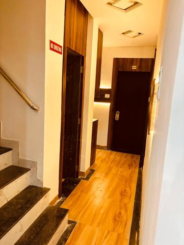 a hallway with a black door and a wooden floor at Airport Hotel Relax Inn in Nagpur