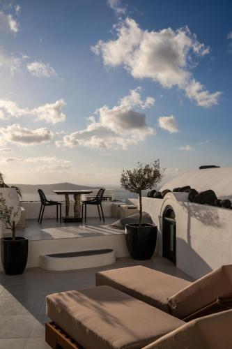a patio with a table and chairs and the ocean at Mill Houses New Elegant Suites in Firostefani
