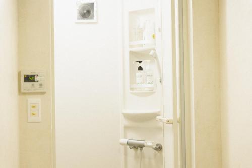 a door leading to a bathroom with a bottle on it at Masukichi -hostel,cafe,souvenir,guide- in Seto