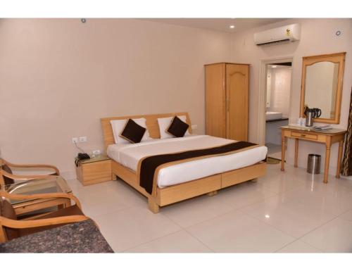 um quarto com uma cama e uma cadeira em Hotel Dolphin, Udhampur em Udhampur