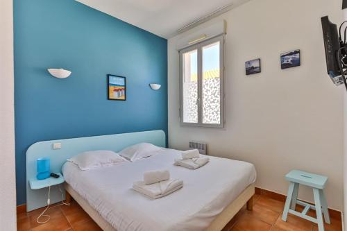 a bed in a room with a blue wall at Résid'Azur - T2 résidentiel avec piscine in Saint-Jean-de-Monts