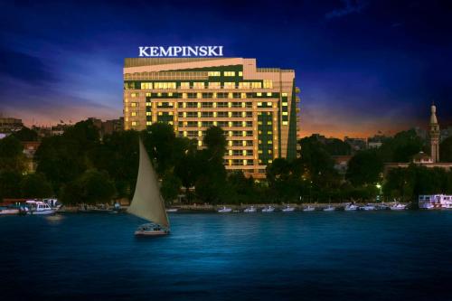 a sail boat in the water in front of a building at Kempinski Nile Hotel, Cairo in Cairo