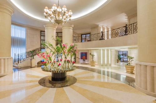 un gran vestíbulo con un gran centro de mesa con flores rosas en Kempinski Nile Hotel, Cairo en El Cairo