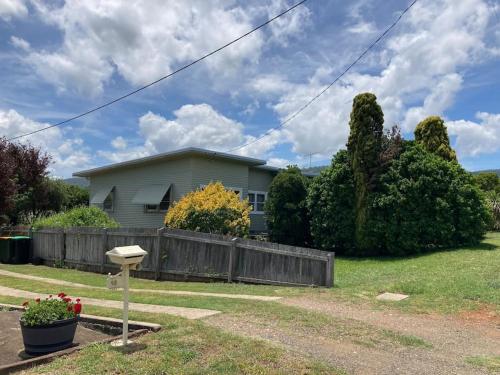a house with a fence in a yard at Philomena's 60s cottage in Scone in Scone