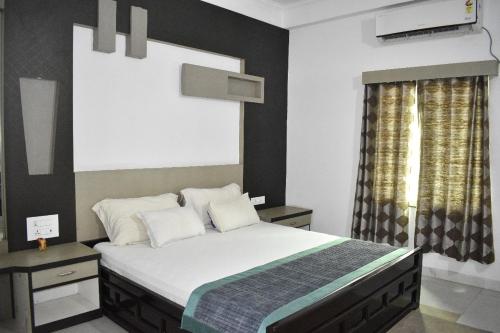 um quarto com uma cama grande e uma janela em MAYUR HOTEL em Dimāpur