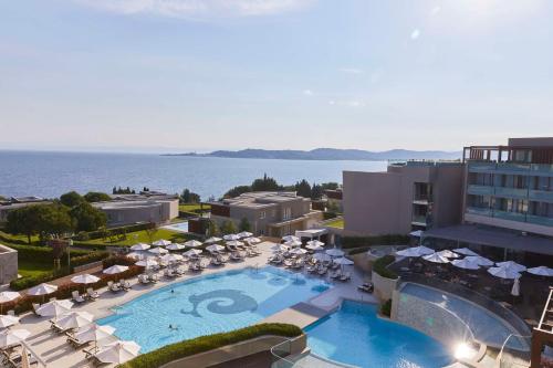 een uitzicht over een hotel met een zwembad, stoelen en parasols bij Kempinski Hotel Adriatic Istria Croatia in Savudrija