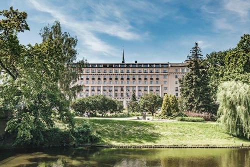 duży budynek z stawem przed nim w obiekcie Grand Hotel Kempinski Riga w Rydze