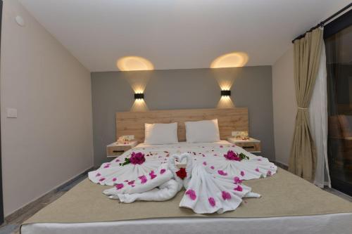 ein Schlafzimmer mit einem großen Bett mit Blumen darauf in der Unterkunft TRAKHEİA OTEL in Marmaris