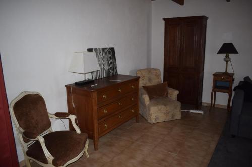 a living room with a dresser and two chairs at Saint Sauveur havre de paix in Saint-Sauveur-Governet
