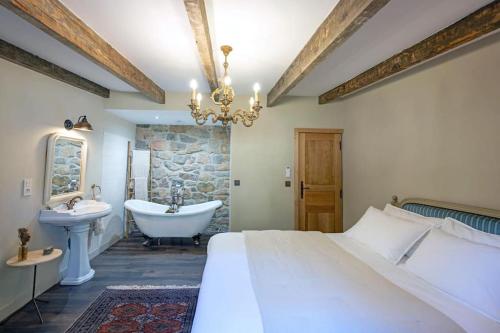 1 dormitorio con cama, bañera y lavamanos en Bergerie de Charme Pedi Lione, en Calenzana