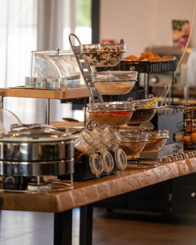 a table with bowls of food and other food items at Kyriad Lyon Sud Sainte Foy in Sainte-Foy-lès-Lyon