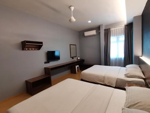 Una cama o camas en una habitación de Lumut Hotel