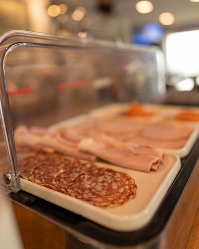 a tray of food with meat and beans on a counter at Kyriad Lyon Sud Sainte Foy in Sainte-Foy-lès-Lyon